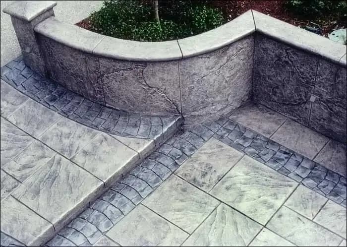 Detailed corner of a stamped concrete retaining wall and steps in Burien, WA, showing contrasting patterns.