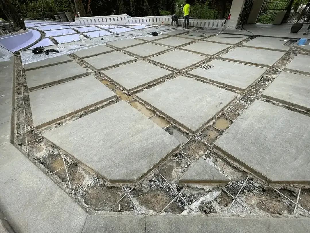 Construction of a custom concrete driveway in Seattle, showing poured pads with rebar grid in the empty channels.