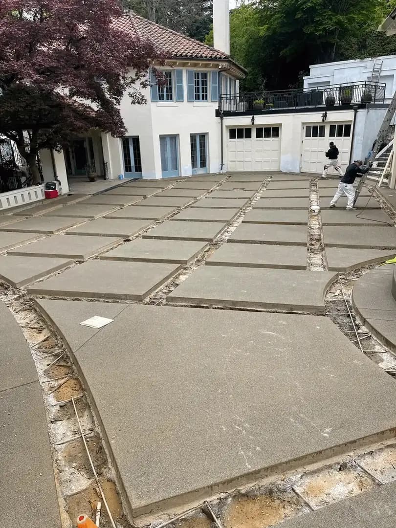 Angled view of the driveway pads in front of a garage, highlighting the precision of the formed grid pattern.