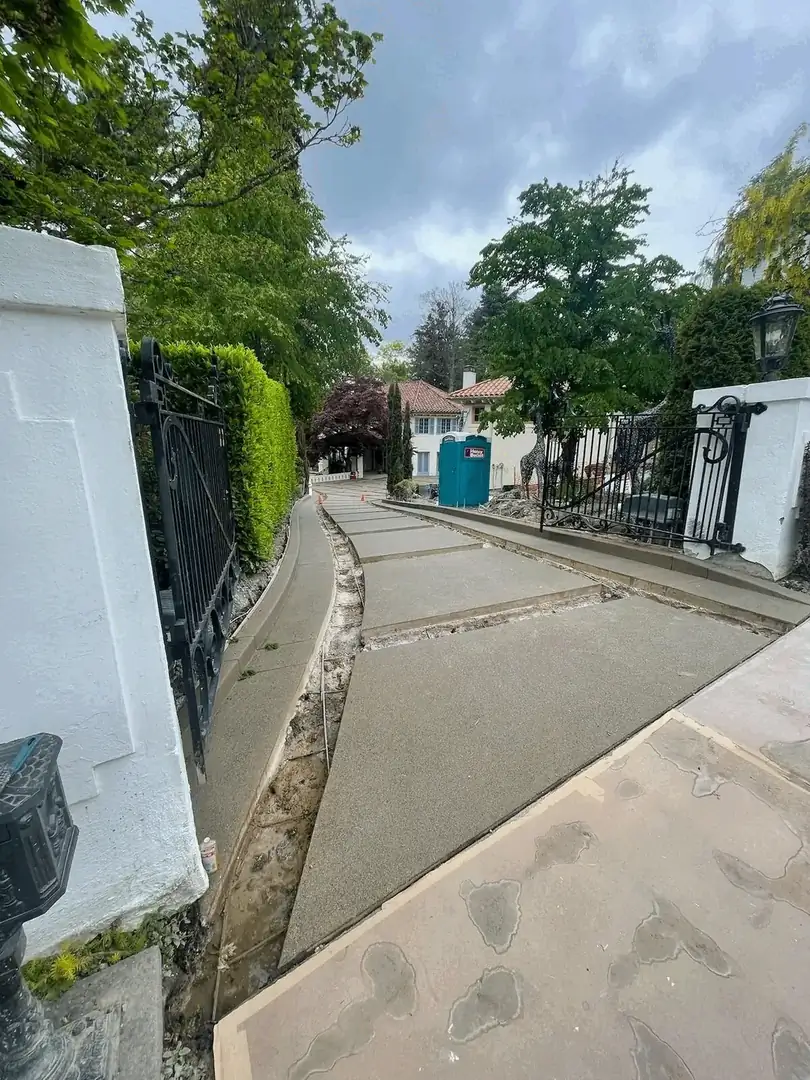 The long entryway of the driveway during construction, showing the formed pads leading from the main gate.