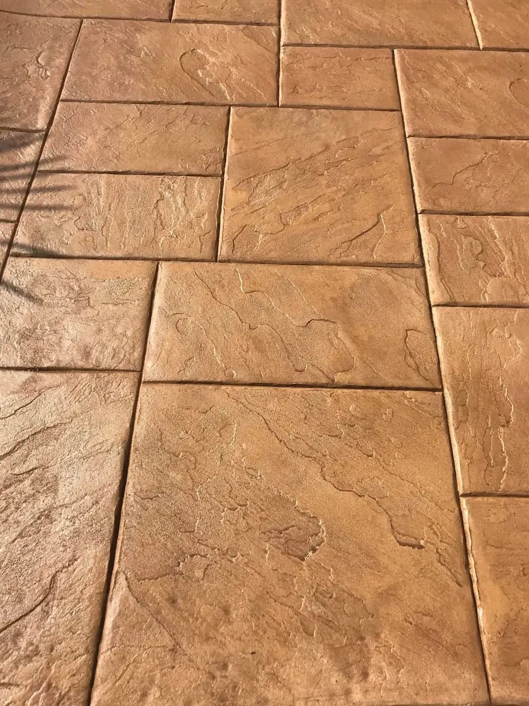 Close-up shot of the stamped concrete texture, highlighting the subtle color variations and slate-like surface.