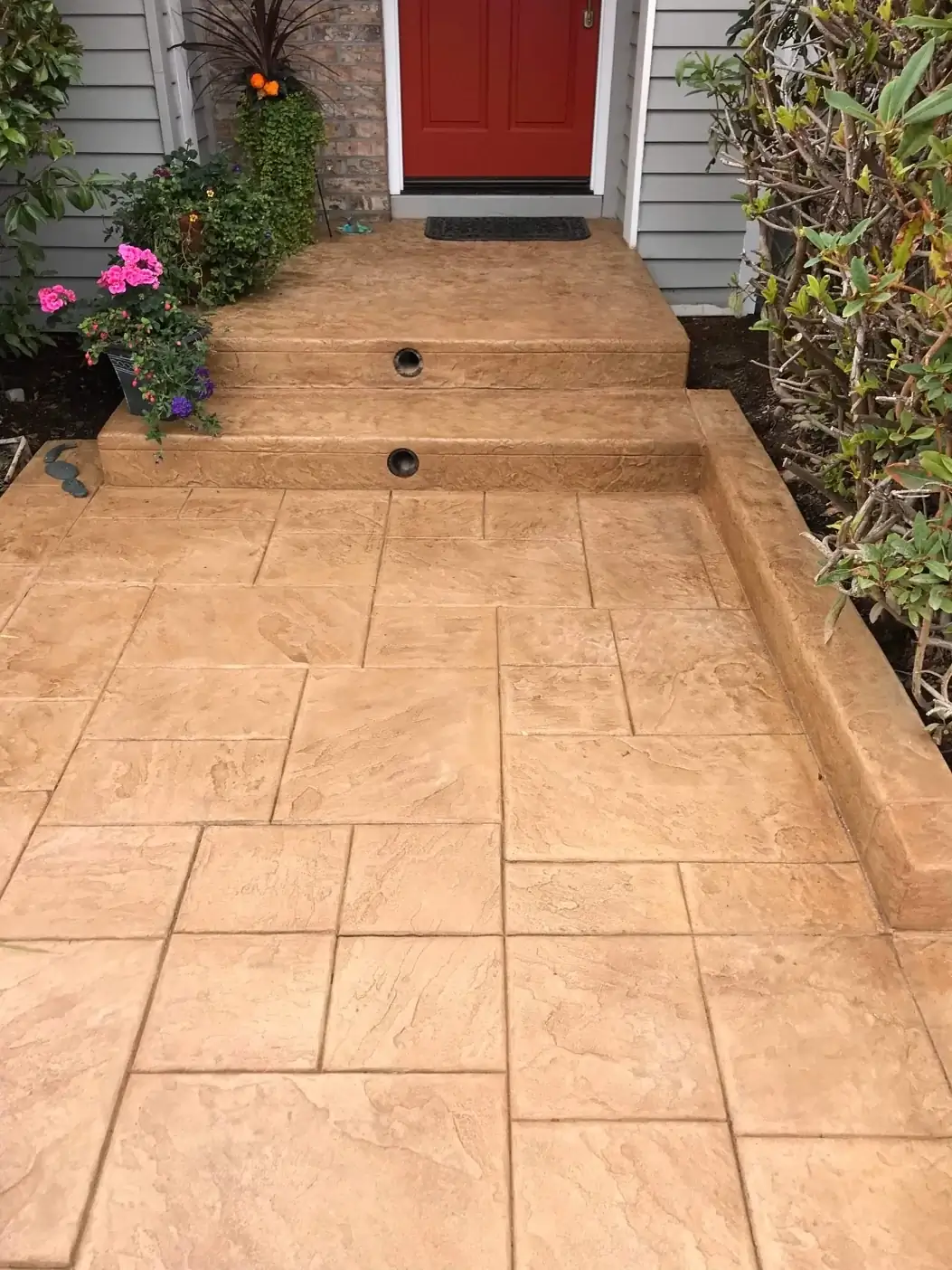 Front porch view of the stamped concrete steps with integrated lighting and a continuous poured concrete curb.