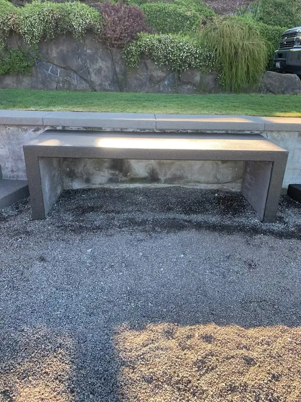 Front view of a modern concrete bench integrated into a retaining wall in a Puyallup waterfront property.