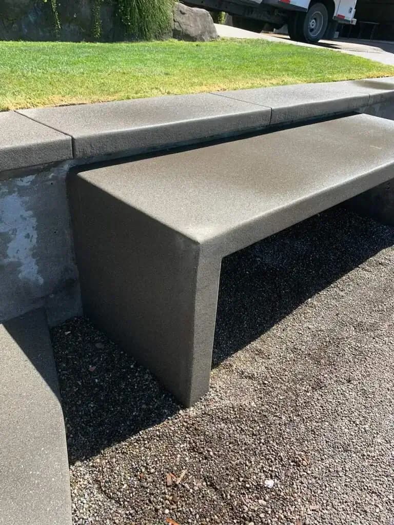 Angled perspective of an integrated concrete seat wall with a dark sand finish in Puyallup, Washington.