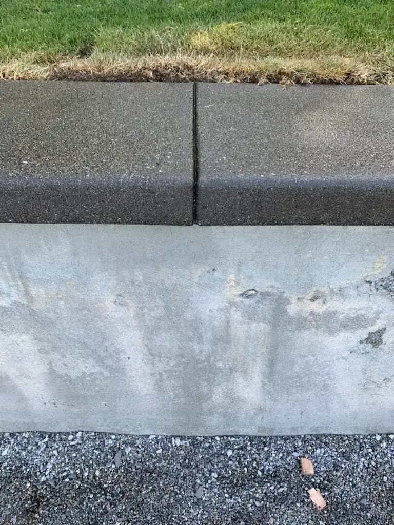 Close-up detail showing the texture of the sand finish on the retaining wall cap next to the vertical face.
