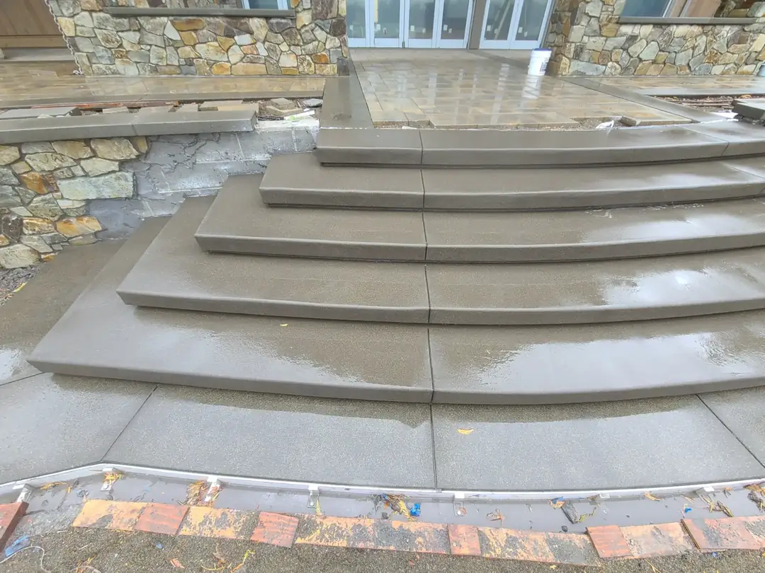A detailed close-up of the custom curved concrete steps in Puyallup, showing the smooth finish and saw-cut joints.