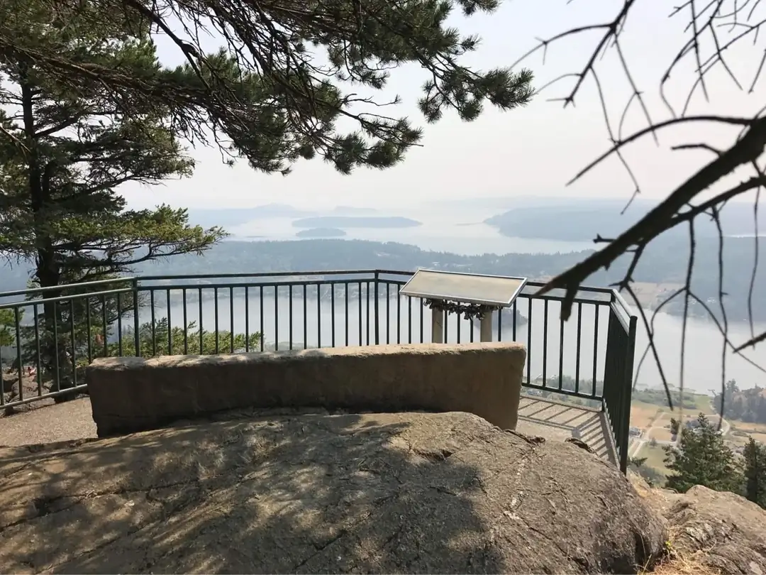 Rear view of the sculpted concrete memorial bench overlooking a bay with islands in Tacoma, Washington.