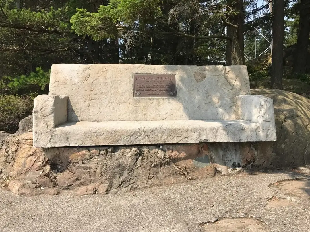 Front view of the concrete bench, showcasing its hand-sculpted armrests and natural, rock-like appearance.