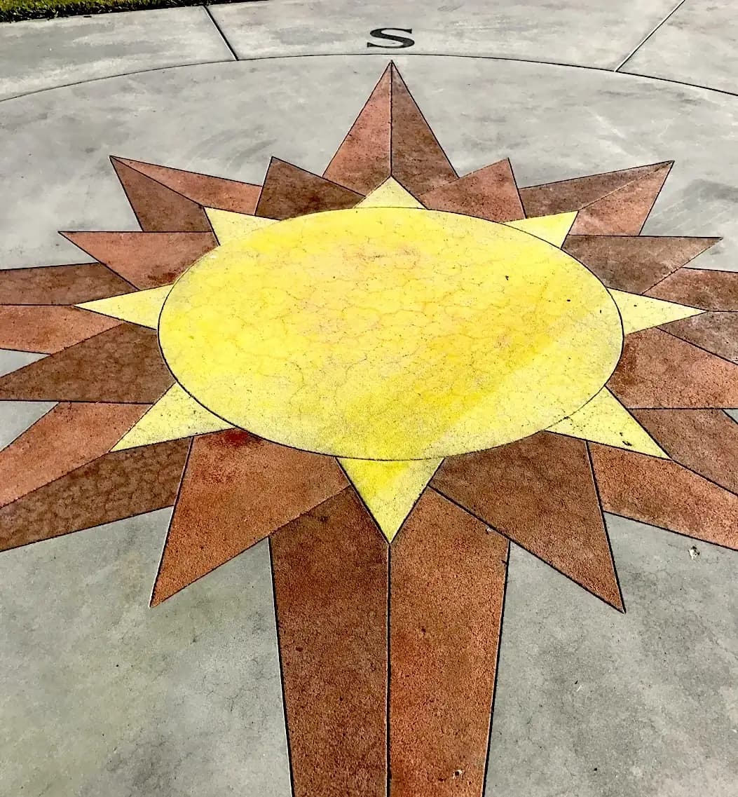 Close-up of the yellow and terra cotta stained concrete star, showing the texture and color application.