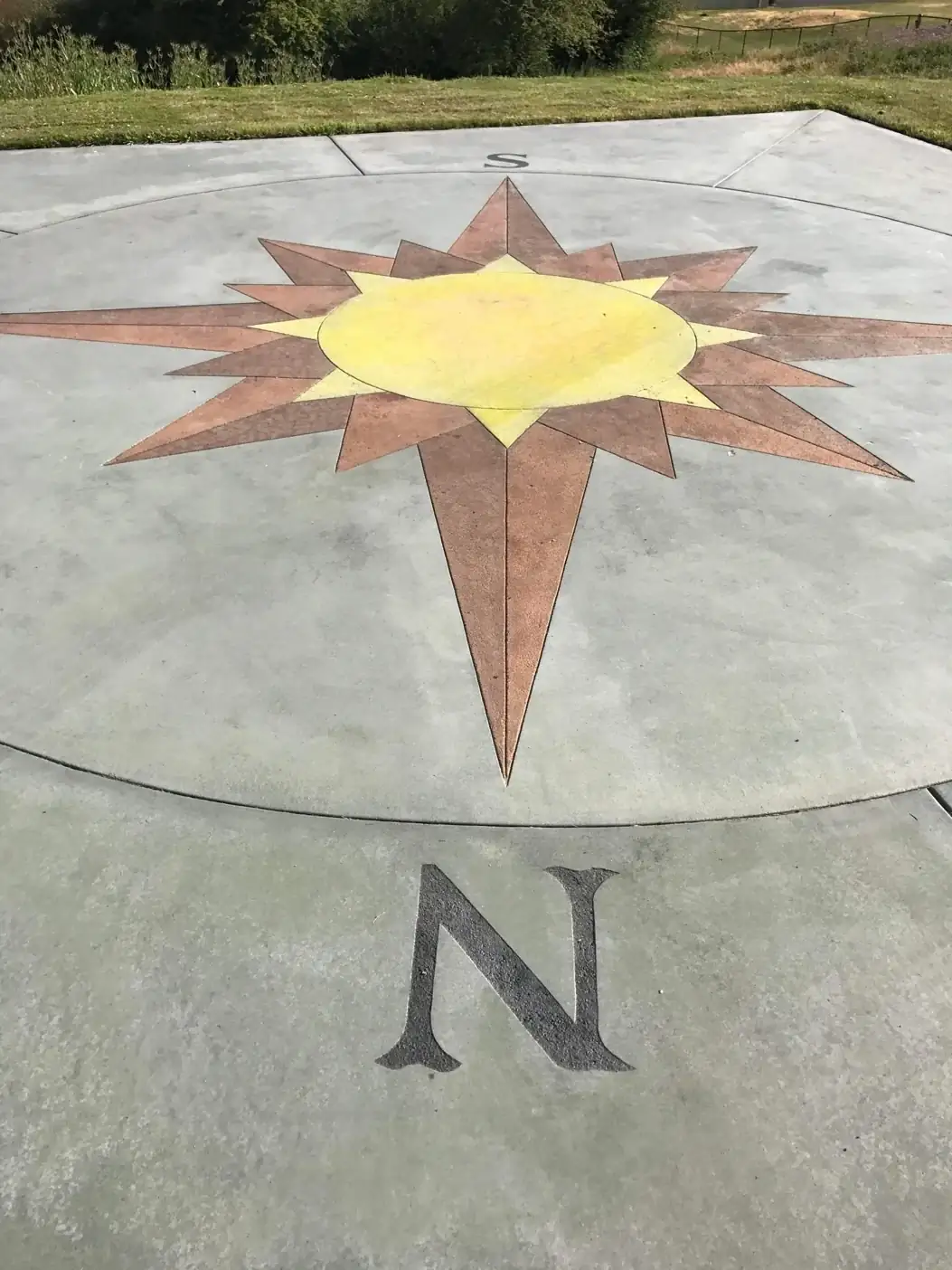 Perspective view focusing on the 'N' cardinal point and the intricate star design on the concrete slab.