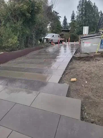 Wide, integrated concrete steps on a modern driveway in Yarrow Point, WA, showing the smooth, dark gray finish.
