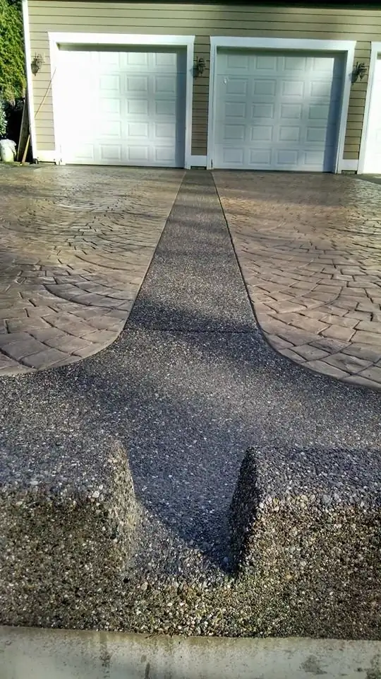View from the street of a stamped concrete driveway in Bellevue, showing the central exposed aggregate drainage channel.