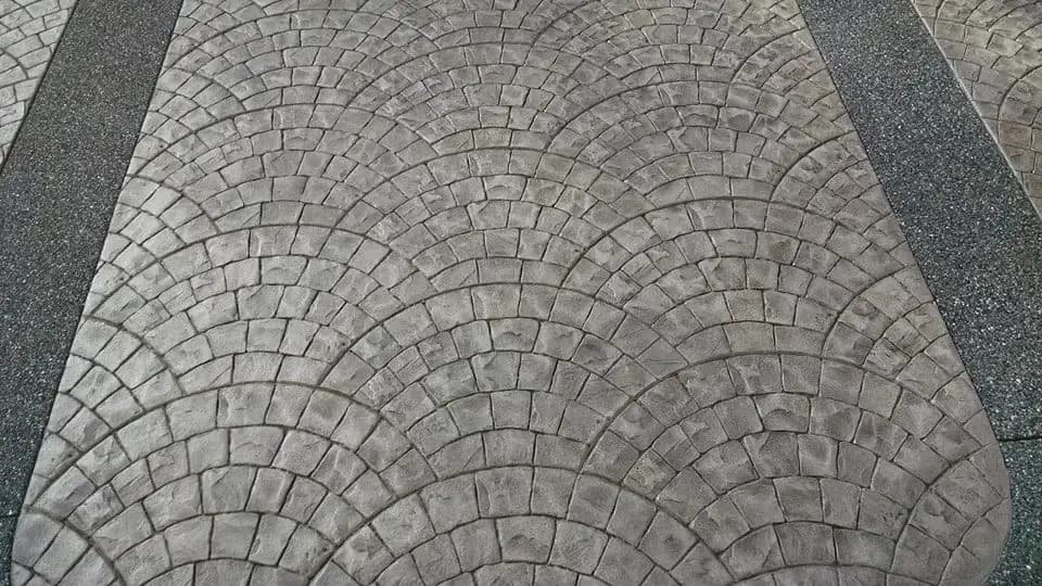The clean lines of the European fan pattern are defined by the contrasting exposed aggregate border strips.