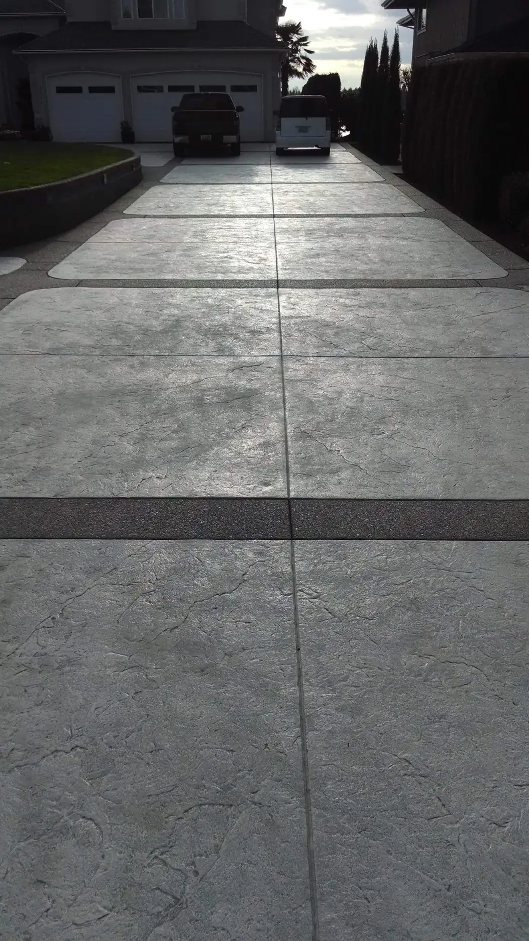 Close-up of the two-tone concrete driveway finish in Tacoma, showing the stamped texture and aggregate border.