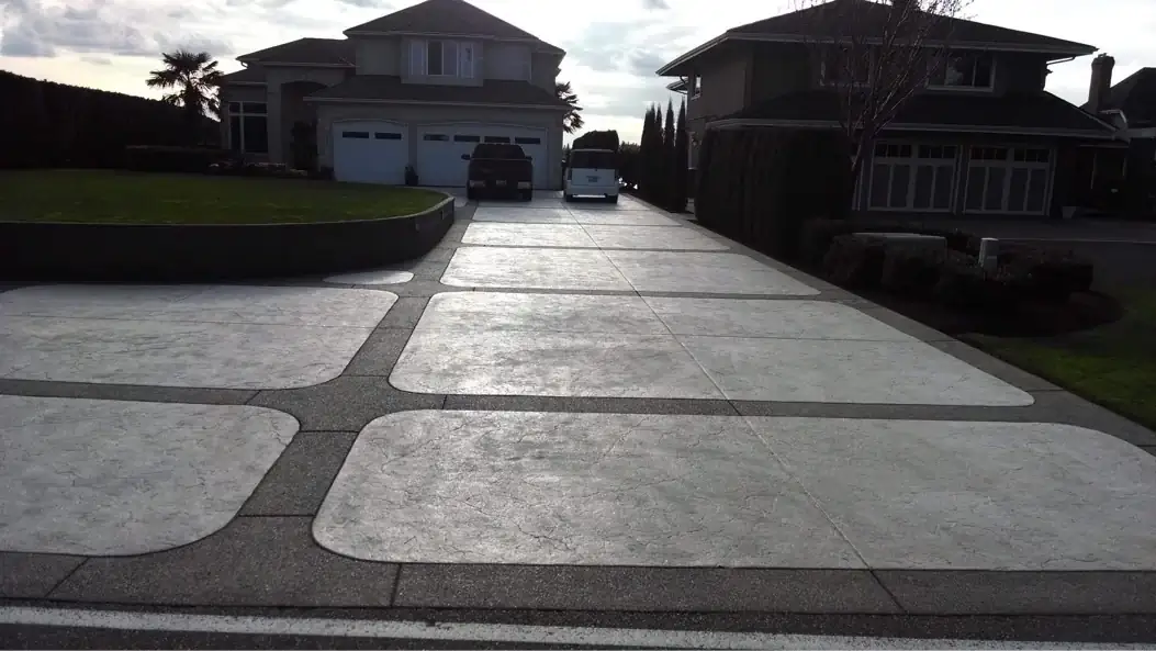 Long perspective shot of the geometric stamped concrete and exposed aggregate driveway leading to a house in Tacoma.