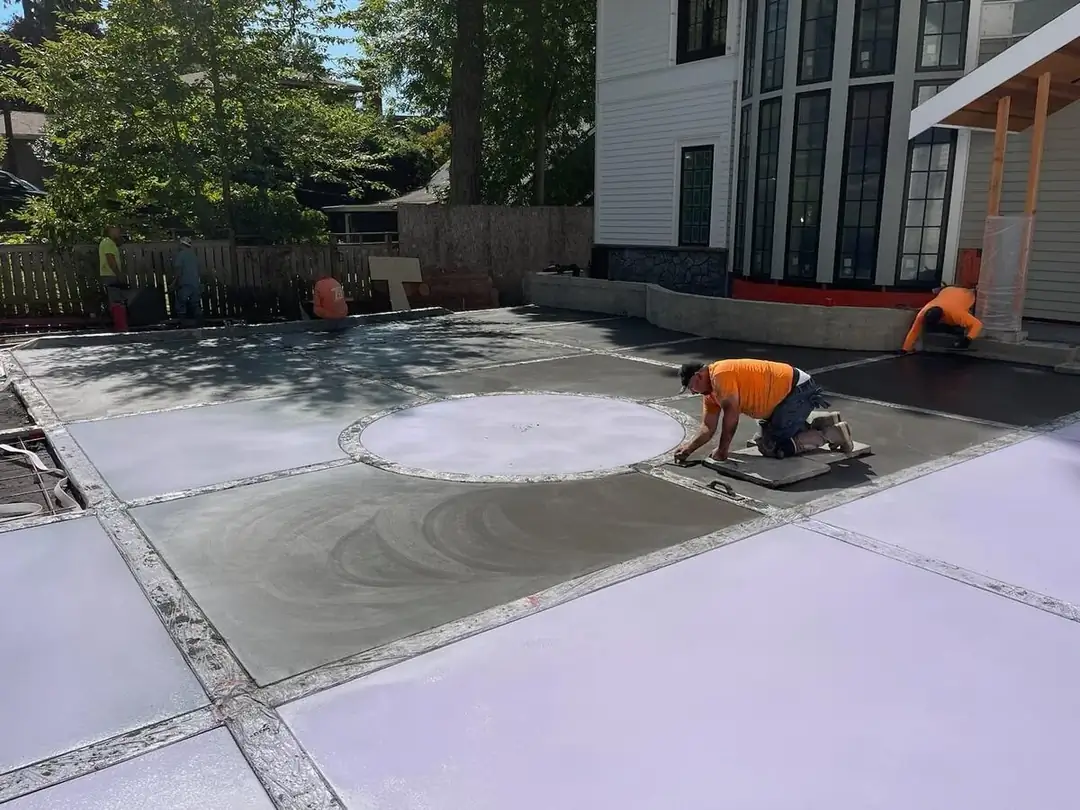 Finishing work on the concrete driveway, with a focus on the circular form for the compass inlay.