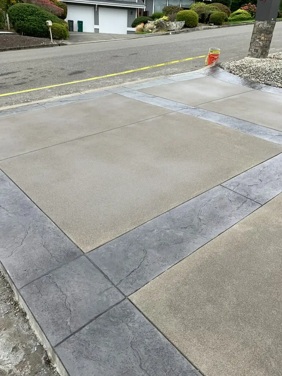 Angled view of the concrete driveway entrance in Federal Way, WA, showing the large stone stamped pattern.
