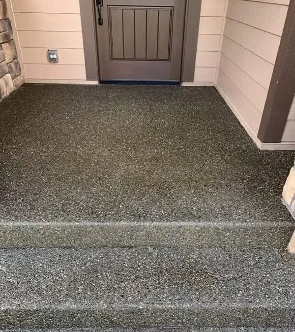 Close-up of exposed aggregate concrete steps leading to a front porch in Alderton, WA, showing the texture.