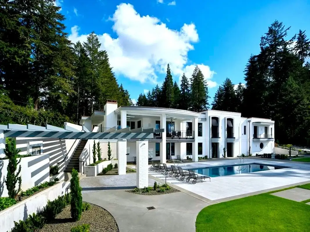 A modern Bellevue estate with a large concrete pool deck and patio area connected by concrete steps and walkways.