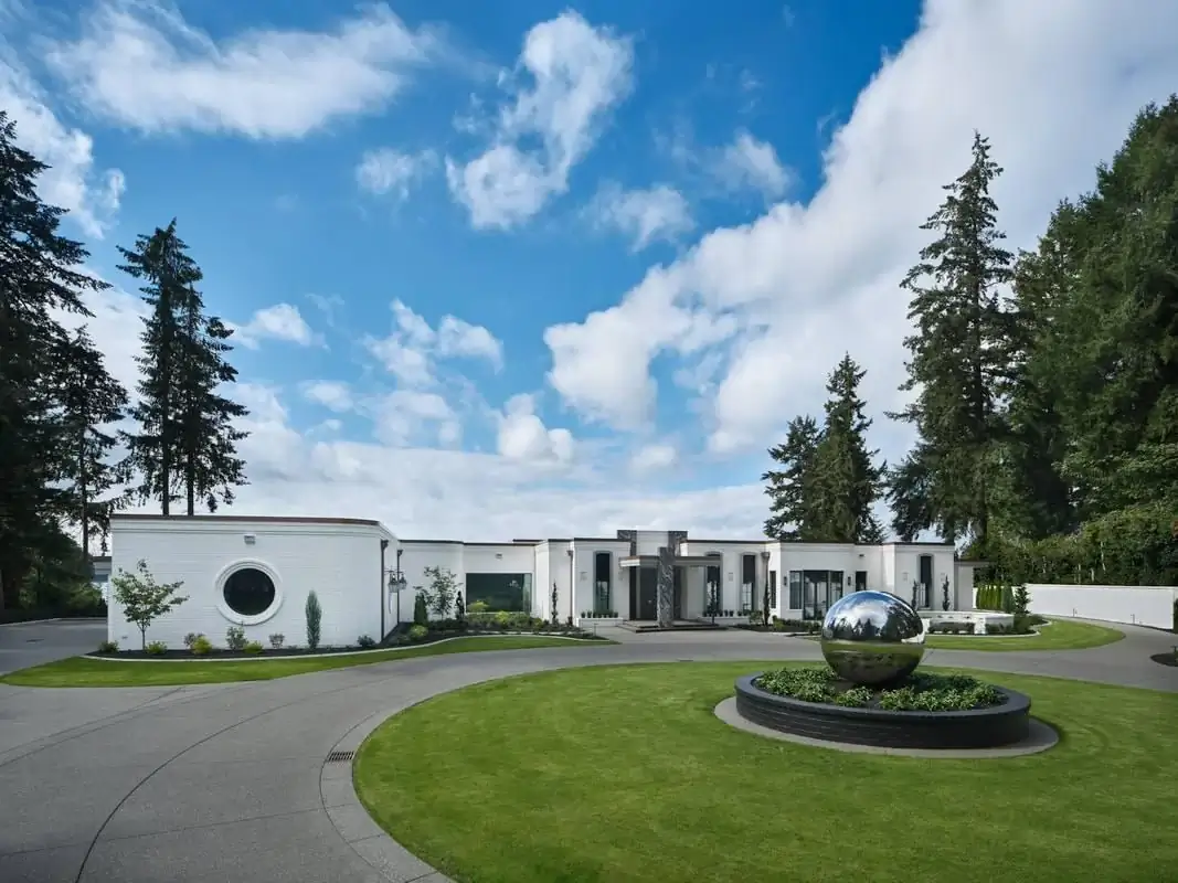 Sweeping circular exposed aggregate driveway at a luxury home in Bellevue with a central landscape feature.