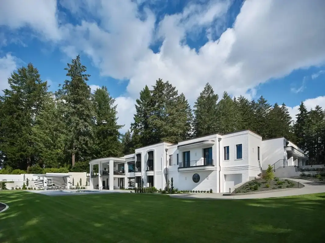 A wide-angle view of the modern residence, showing the relationship between the driveway, lawn, and home.