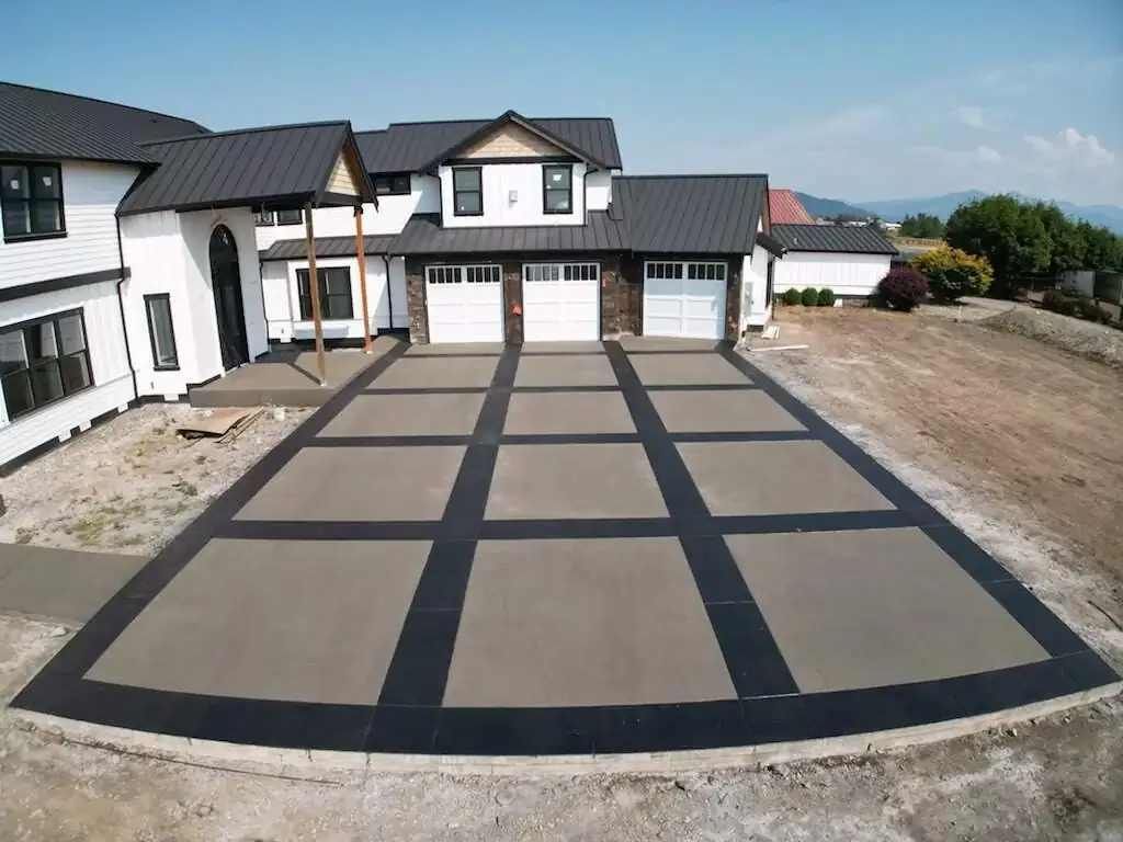 Front view of the large concrete driveway in Puyallup, showing the stamped border and sand finish panels.