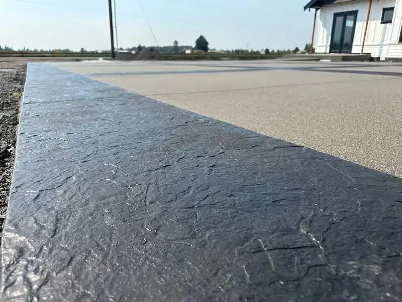 Detailed close-up of the dark, stamped concrete border showing its seamless slate texture.