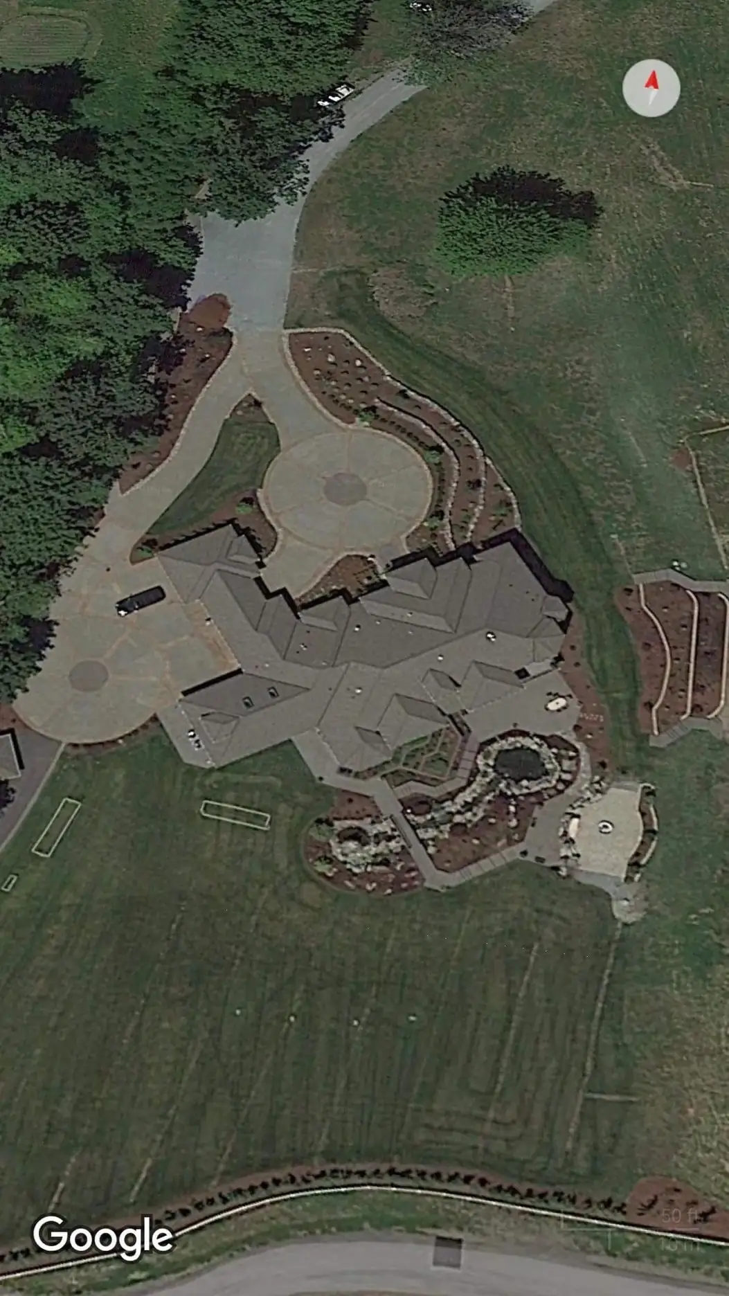 Aerial view of a large residential property showing the full scope of the custom concrete driveway and patios.