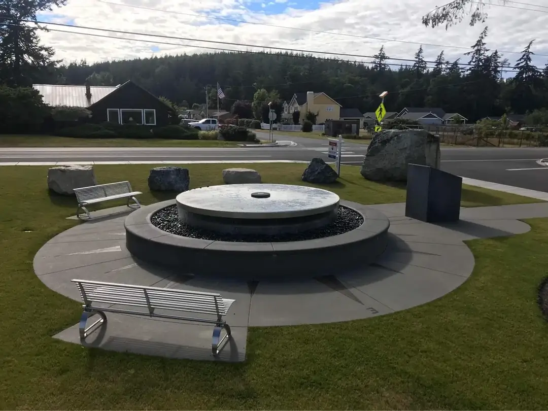 Wide angle shot of the circular concrete plaza and fountain in a public park setting in Bellevue, WA.