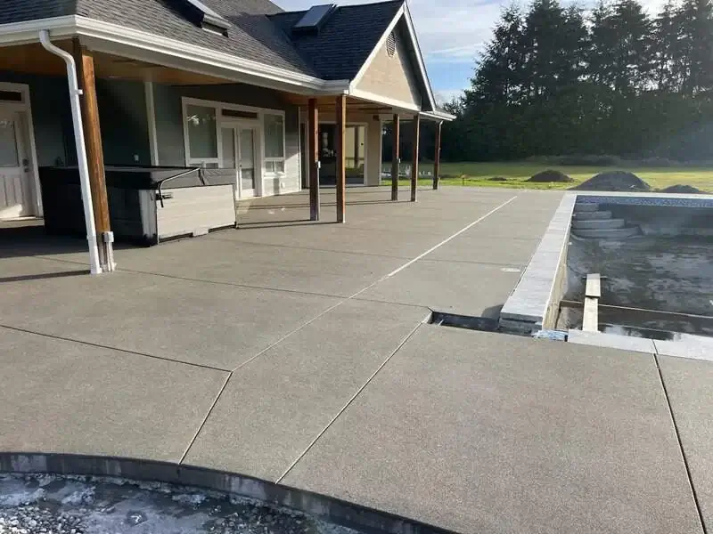 A detailed look at the saw-cut control joints on a large concrete patio with a sand finish in Puyallup.