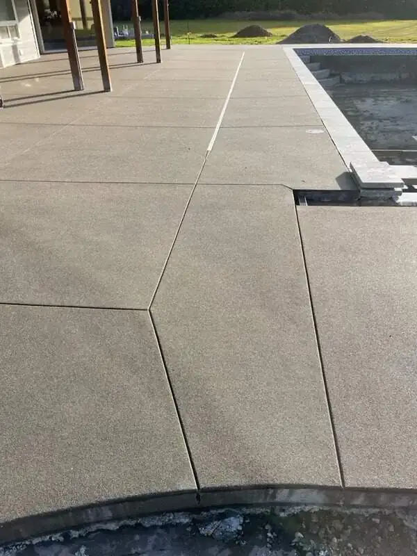 Angled view of the concrete patio demonstrating the geometric layout of the saw-cut pattern near a support post.