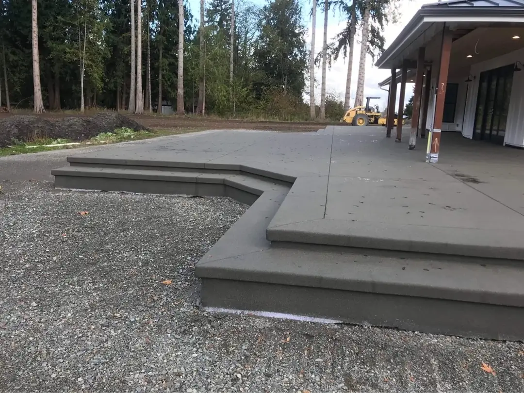 Detailed shot of the angular concrete steps and saw-cut pattern on a new sand finish patio installation.