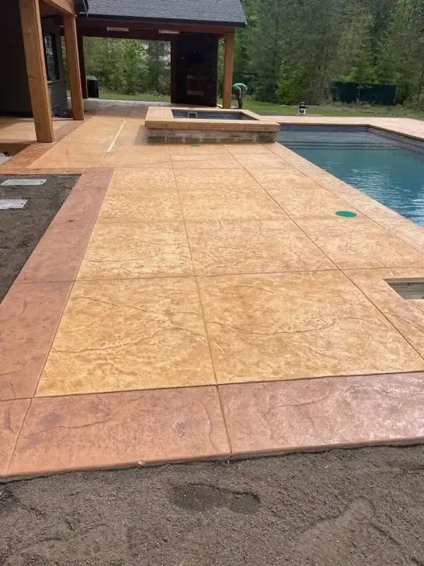 Close-up of the random stone stamped concrete pattern on a new patio in Puyallup, highlighting the texture.