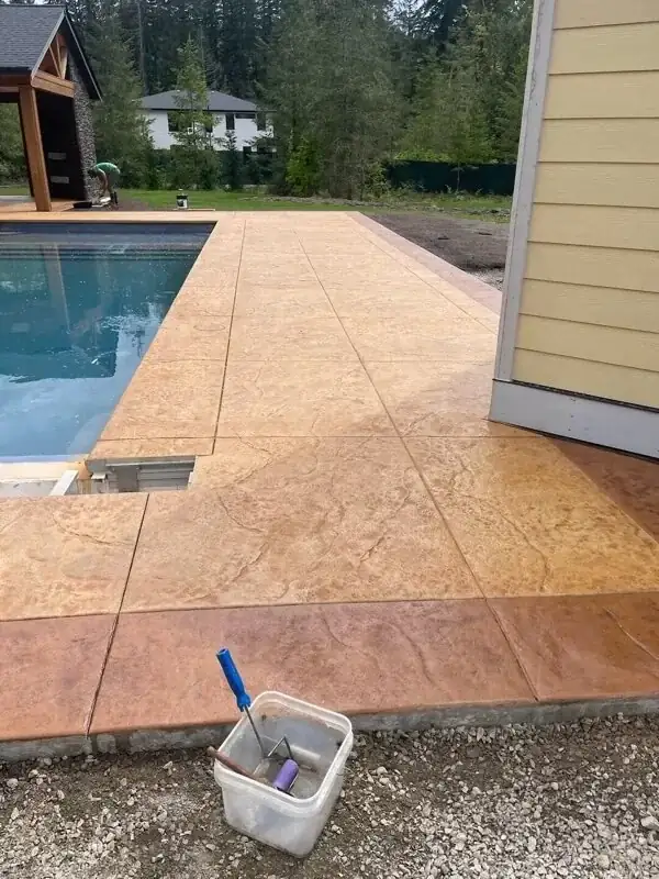 The integrated concrete coping around the hot tub and pool in Puyallup, with a smooth, safe edge.