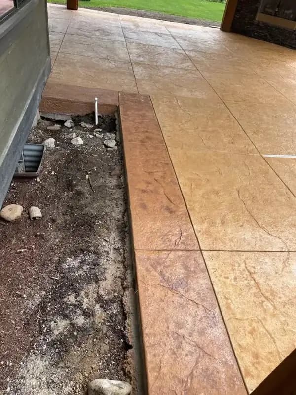 Angled view of the stamped concrete pool deck, showing the depth of the random stone pattern.