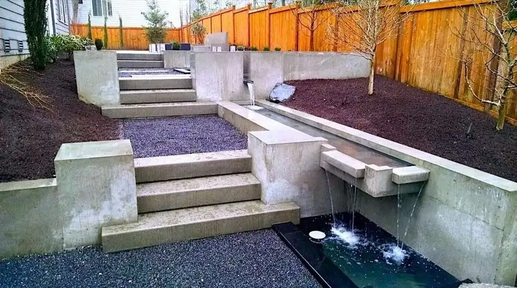Wide shot of the terraced concrete landscape, showing the relationship between steps and the water feature.