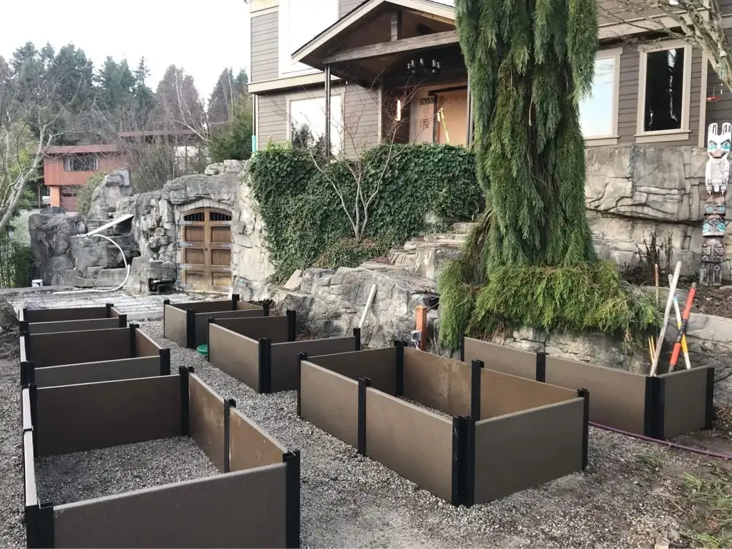 View of the newly installed retaining wall planters arranged in rows in front of a modern home's rockery.