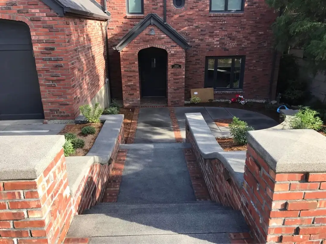 View from the top of concrete steps looking down a walkway with stamped borders in Tacoma, WA.