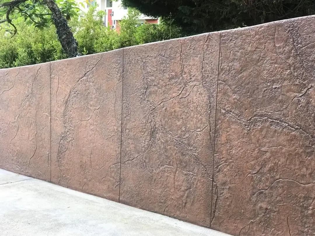 Close-up view of the textured random stone pattern on a stamped concrete retaining wall in Tacoma.