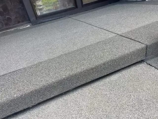 Exposed aggregate concrete steps with clean saw-cut joints leading to a residence in Puyallup, WA.