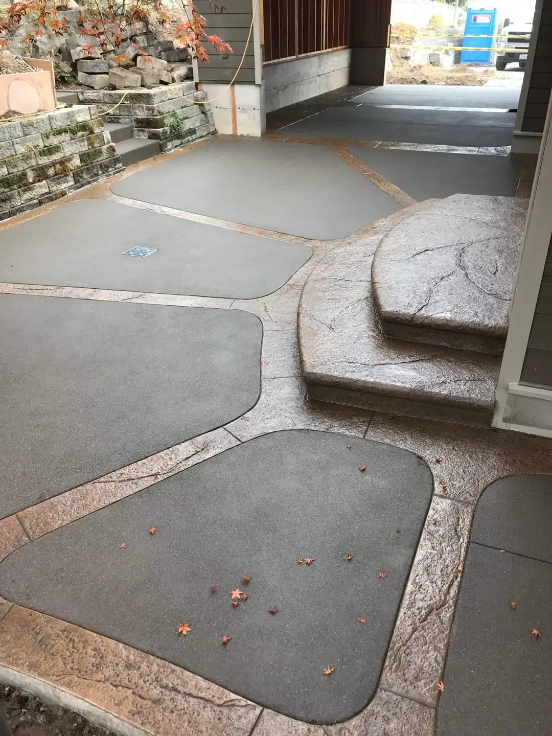 Angled perspective of the stamped concrete patio in Puyallup, showing the integrated drain and textured step risers.