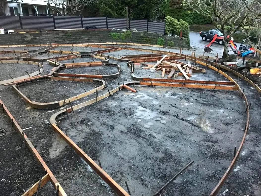 Complex curved formwork and rebar grid during the site preparation for a custom driveway in Puyallup.