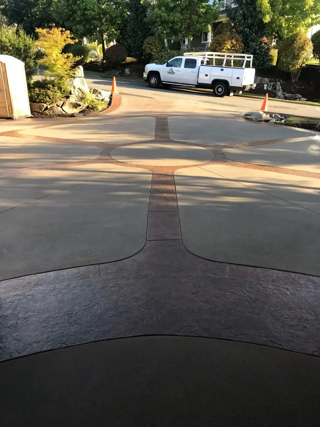 View from the street showing the circular stamped concrete element and driveway entrance.