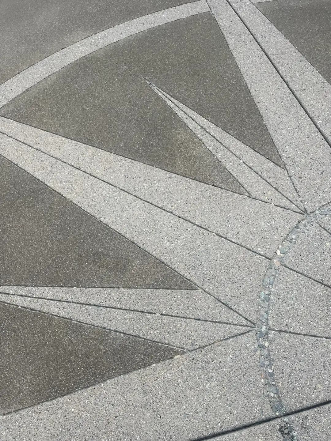 Close-up detail of the saw-cut joints and two-tone sand finish on the compass rose medallion.