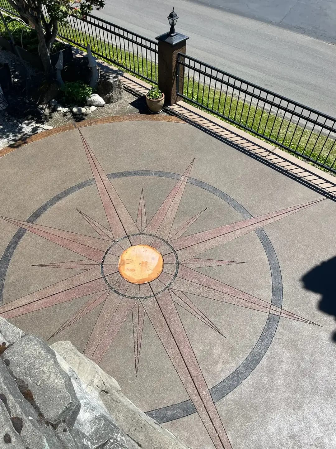 High-angle shot of the sealed concrete patio, highlighting the vibrant colors of the compass rose design.