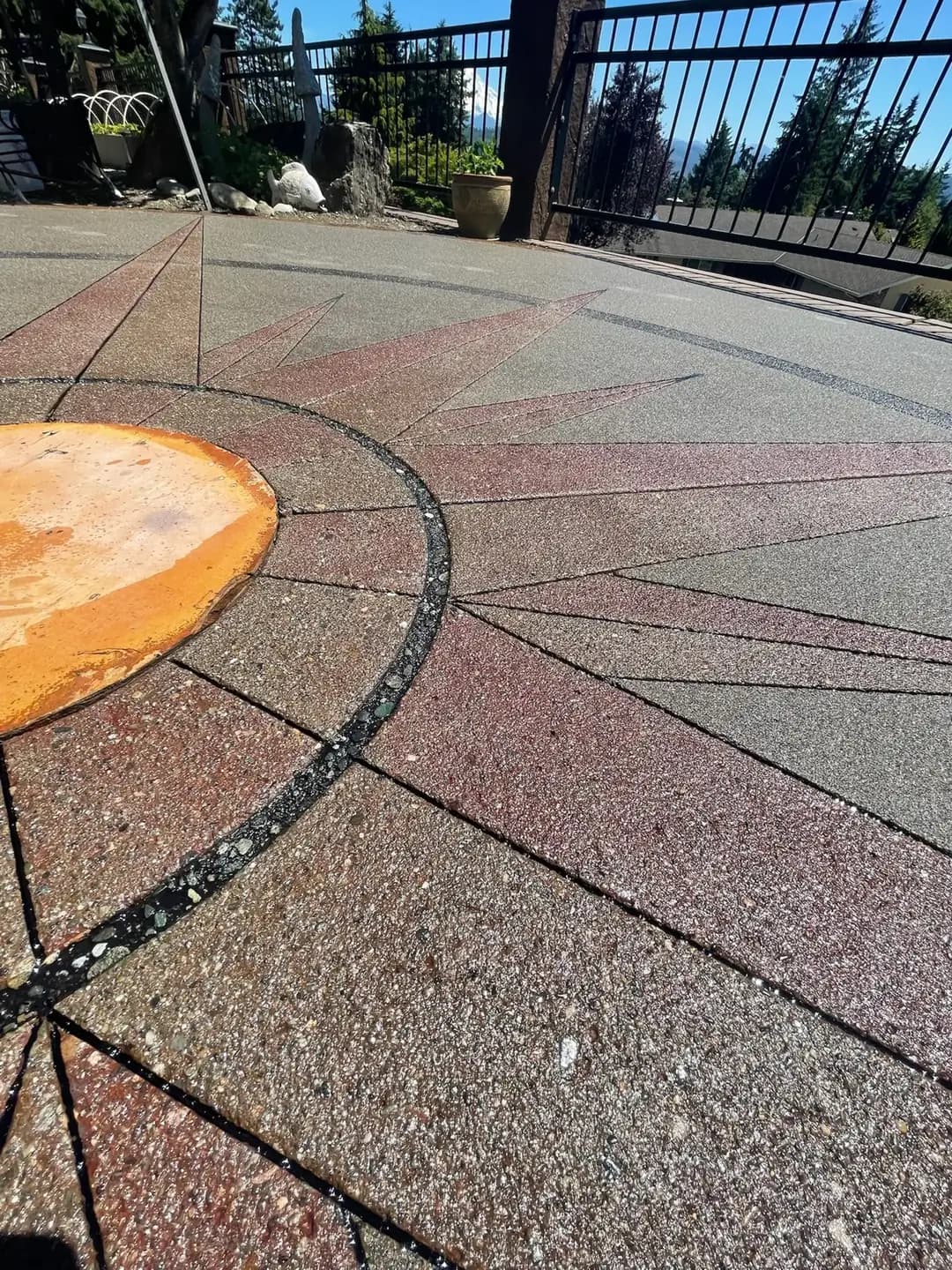 Angled close-up of the exposed aggregate textures and the dark circular band within the compass design.
