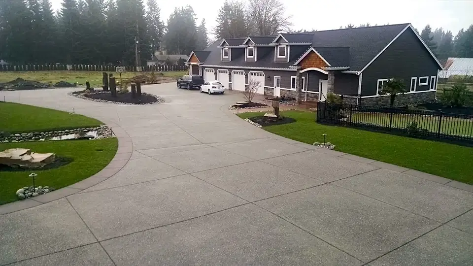 Wide angle of a large residential property in Bellevue showing an exposed aggregate driveway with a smooth border.