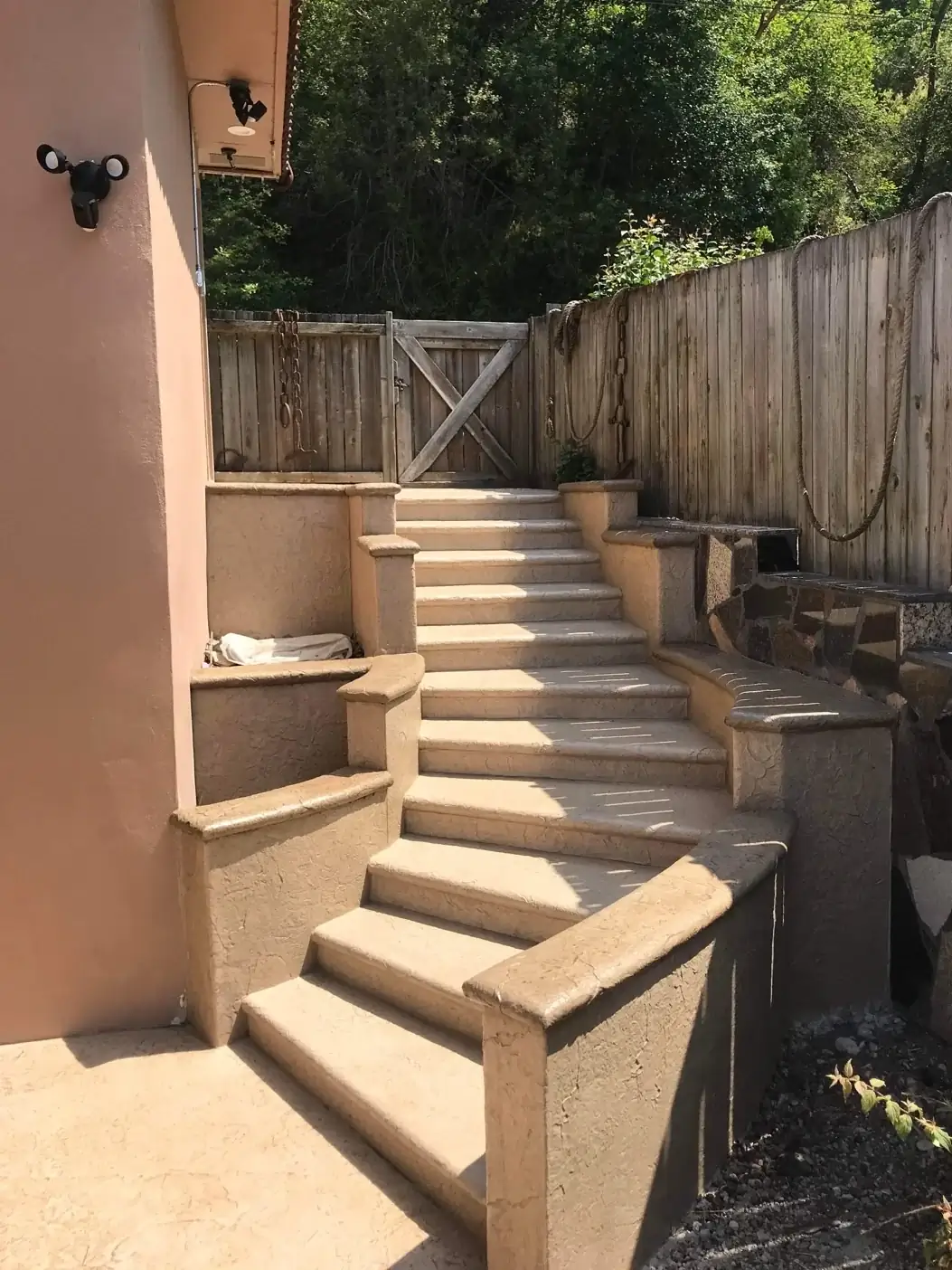 A complete view of the stamped concrete staircase and retaining wall system integrated with the home.