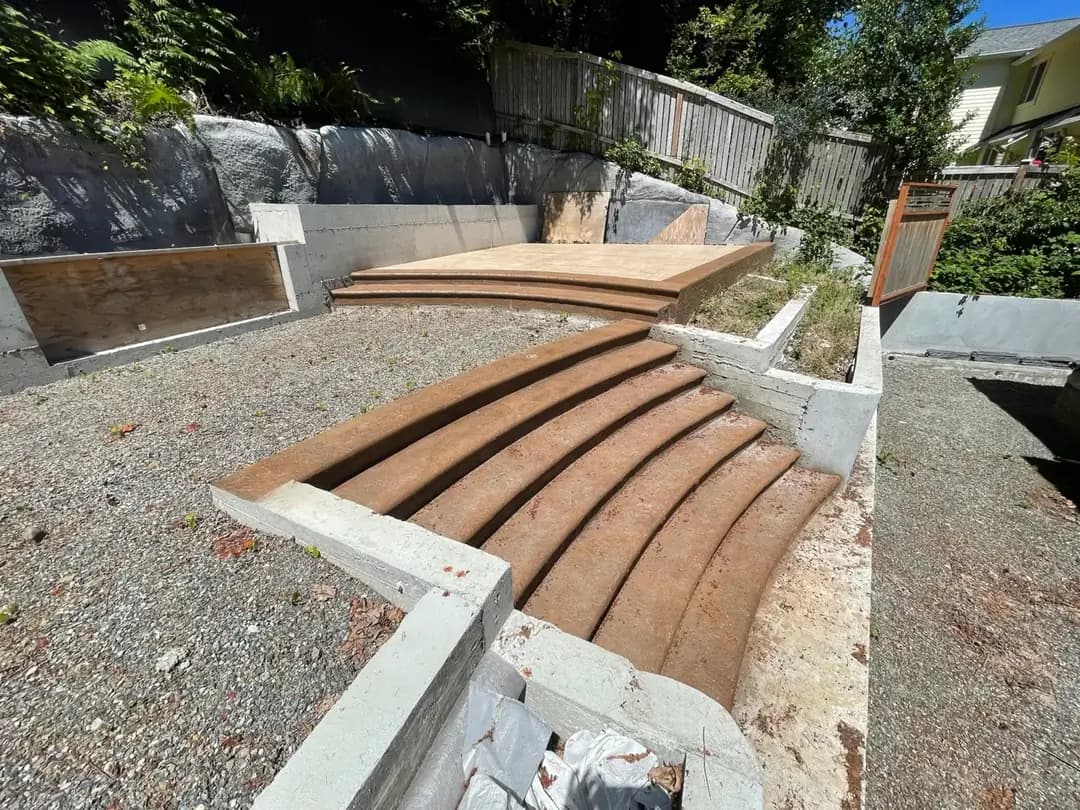 Initial phase of a multi-level stamped concrete project in Bellevue showing curved step forms and a raised platform.