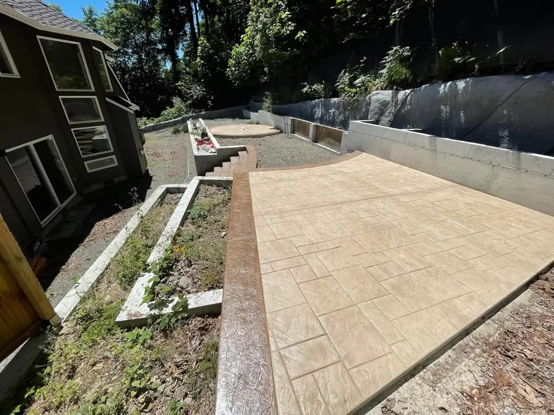 Overhead view of a new ashlar slate stamped concrete patio and walkway in Bellevue with a dark textured border.